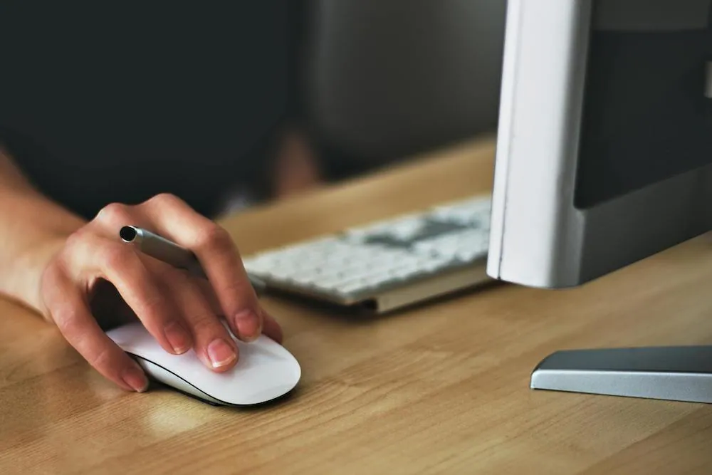 hand on mouse at computer